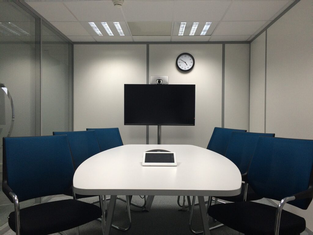 Empty meeting room, half-moon table, blank computer screen